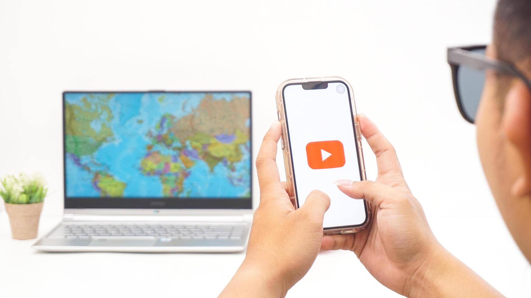 Yogyakarta, Indonesia, 2025 - Man holds smartphone showing Youtube platform application on the screen isolated on white background photo