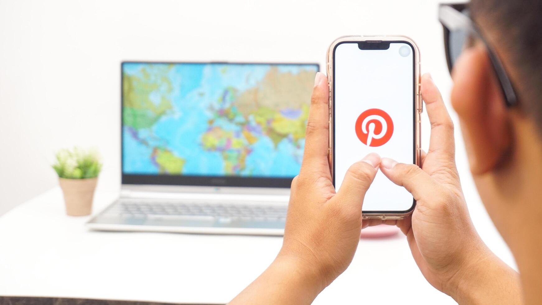Yogyakarta, Indonesia, 2025 - Man holding smartphone with Pinterest, visual discovery platform application on the screen isolated on white background photo