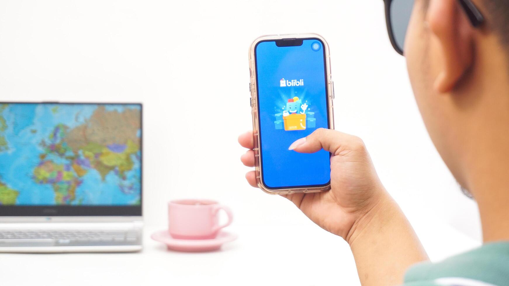 Yogyakarta, Indonesia, 2025 - Man holds smartphone with Blibli, electronic commerce platform in Indonesia application is loaded on the screen isolated on white background photo