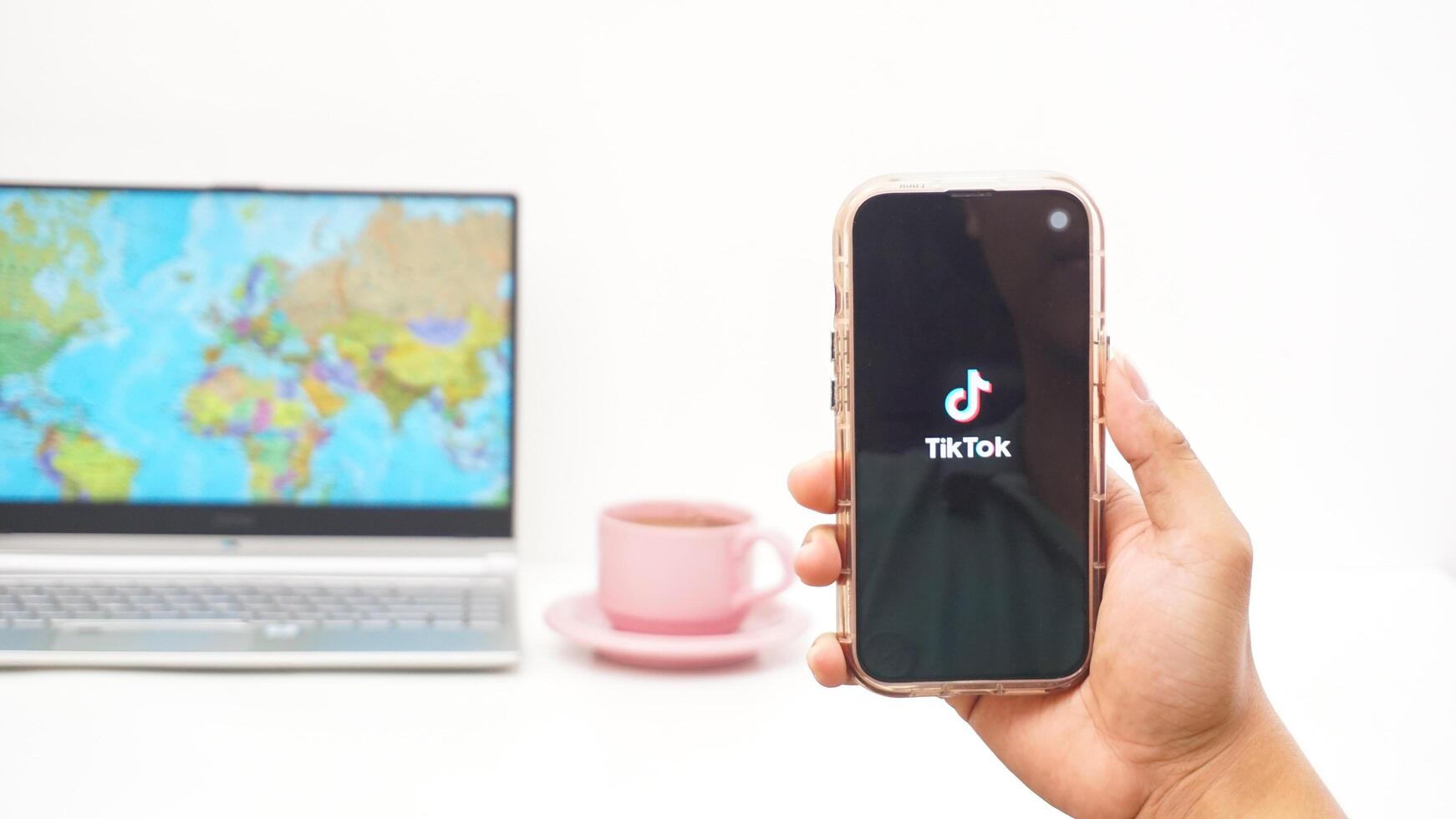 Yogyakarta, Indonesia, 2025 - Man open Tiktok, social and entertainment platform application on the smartphone isolated on white background photo