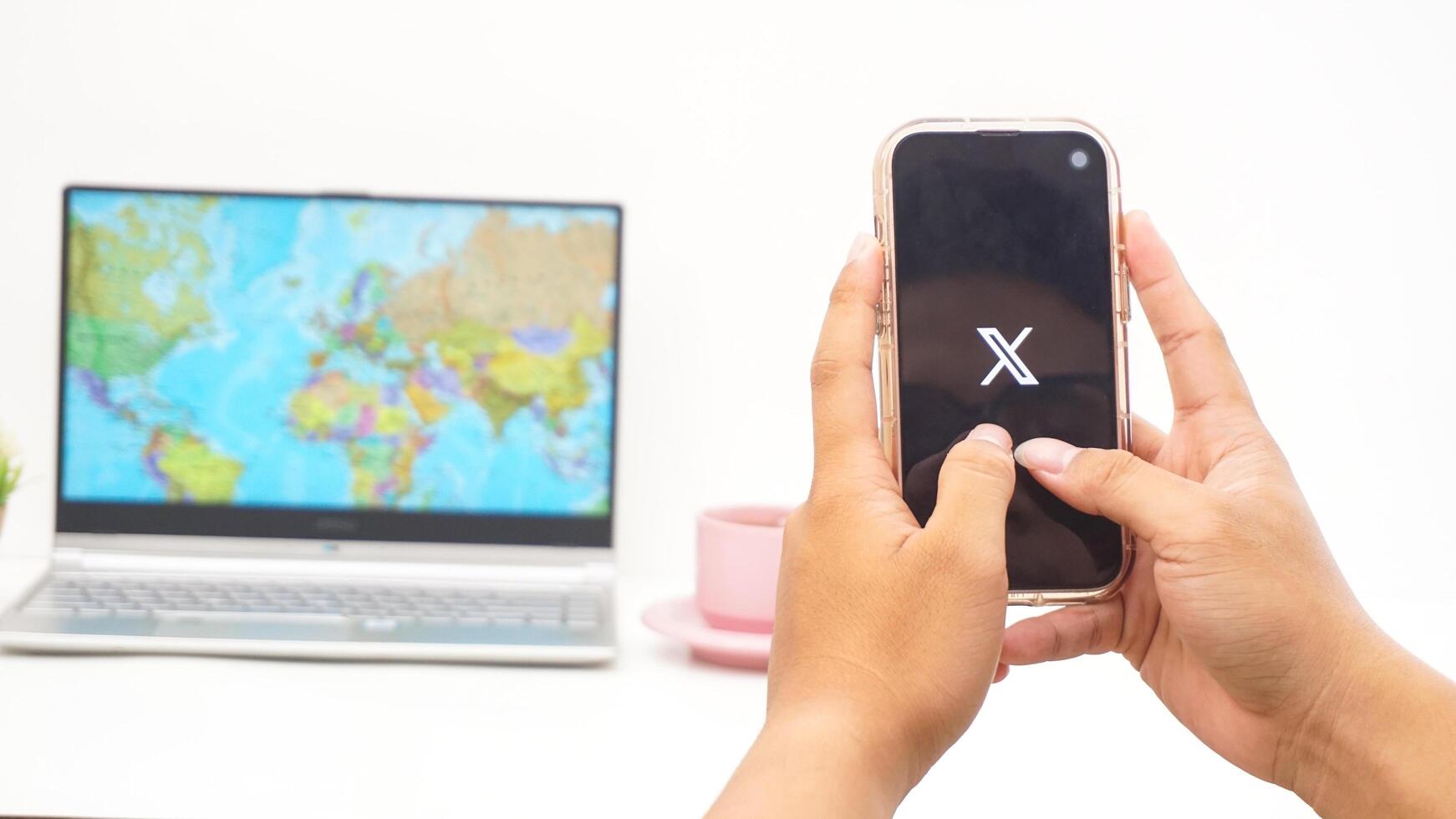 Yogyakarta, Indonesia, 2025 - Man holding smartphone with X former Twitter social media platform application on the screen isolated on white background photo