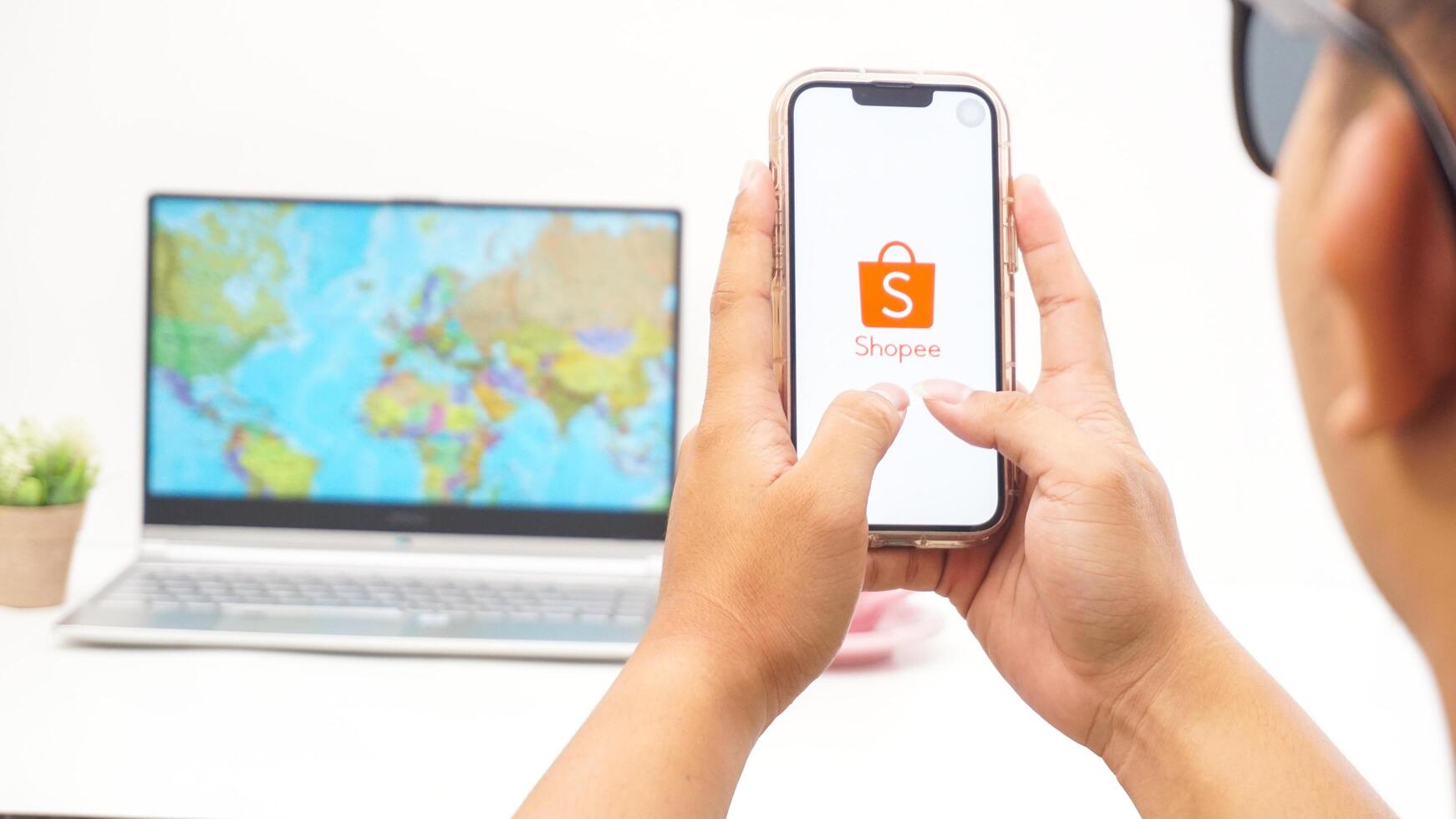 Yogyakarta, Indonesia, 2025 - Man holds smartphone with Shopee, electronic commerce or online shopping platform application on the screen isolated on white background photo