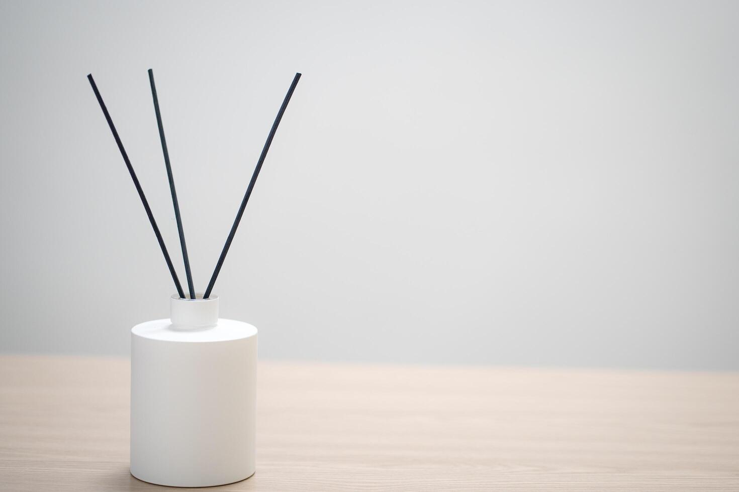 perfume for home. aromatic reed diffuser with sticks and flowers in a vase on a wooden table. the concept of tranquility, relaxation and enjoyment photo