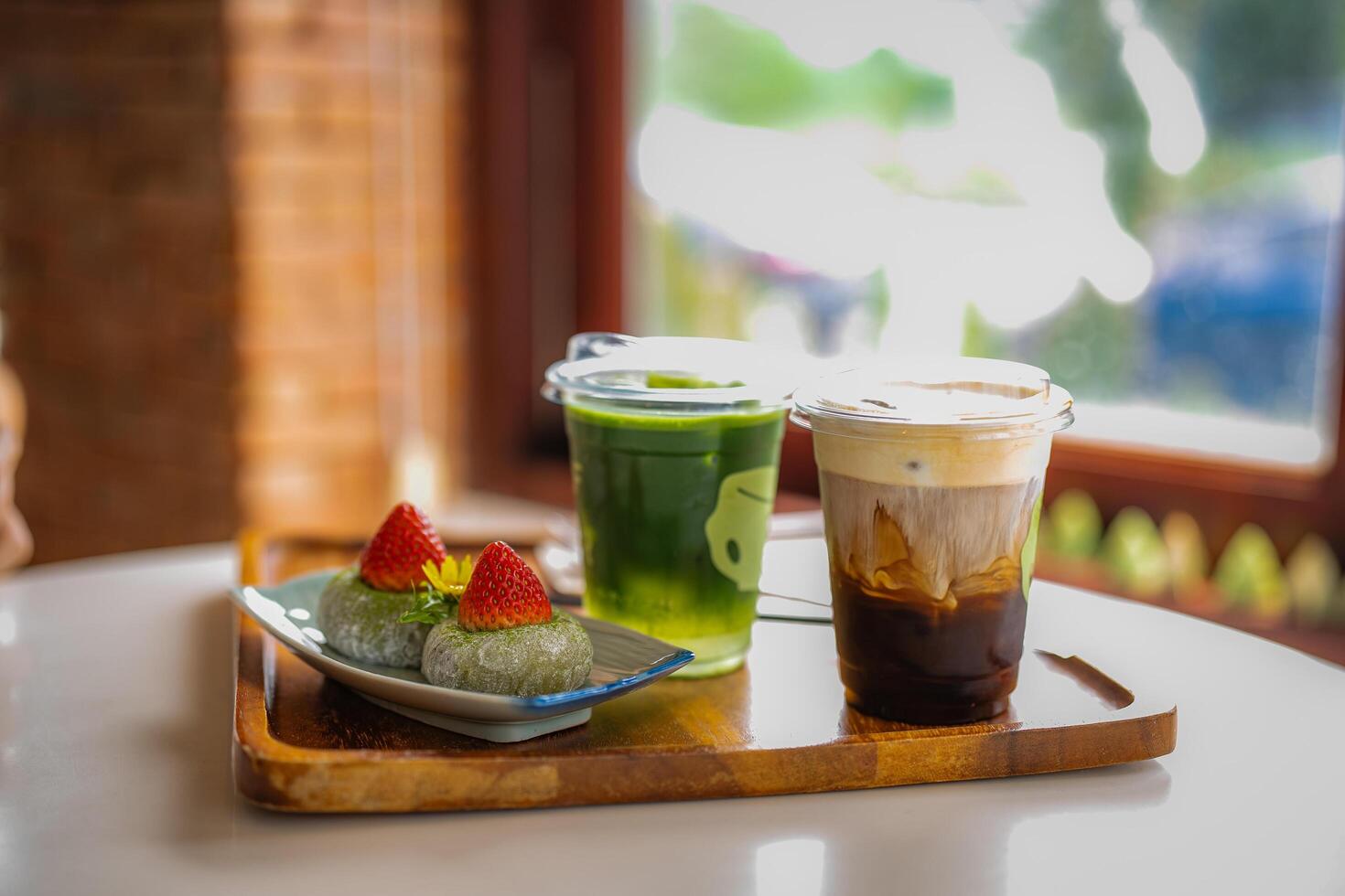 green tea moji daifuku sweets in plate with ice cofee and ice matcha green tea on table at cafe photo