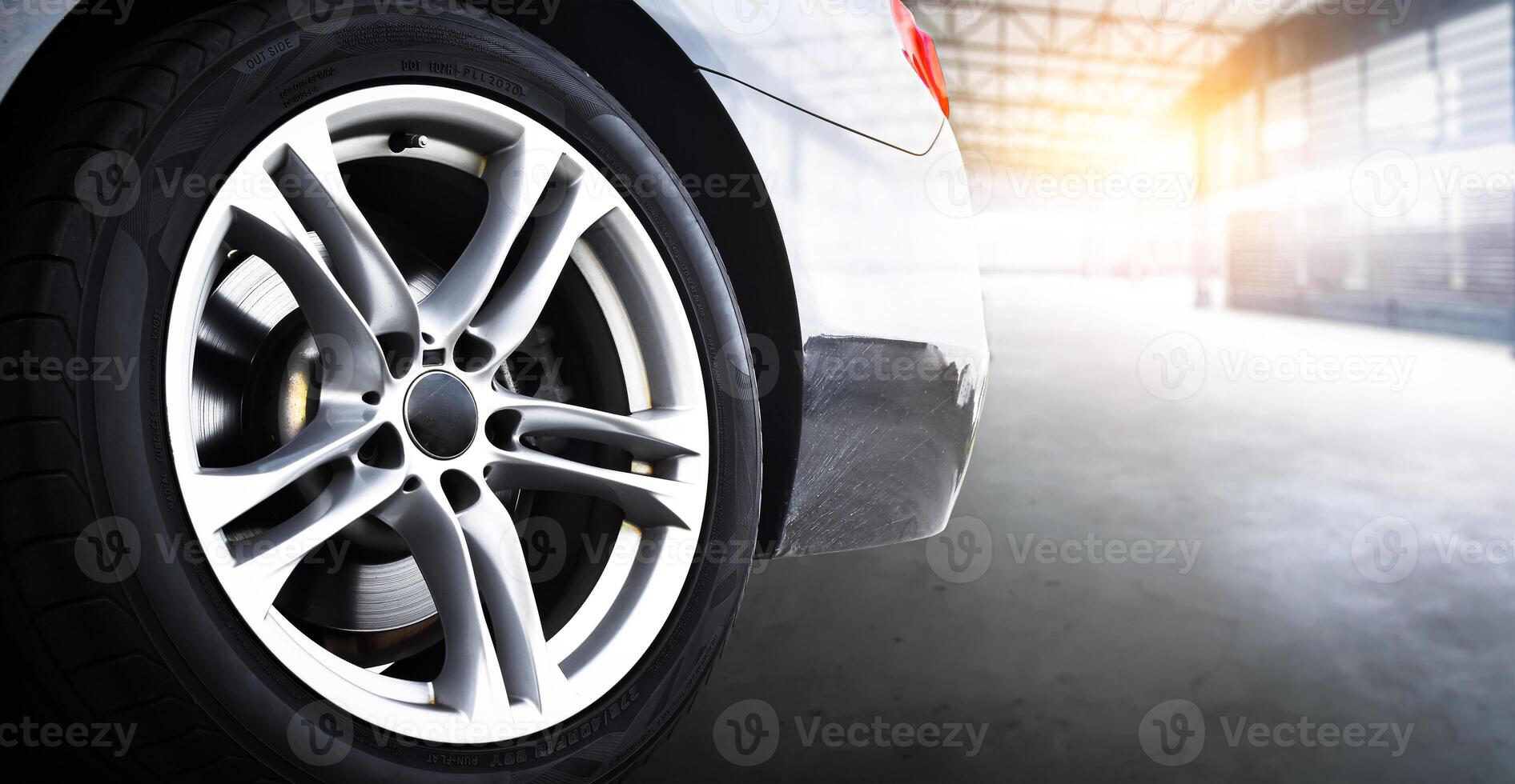 Car Wheel Rim, Close-up of a car alloy wheel rim and tire in garage with sunlight. photo