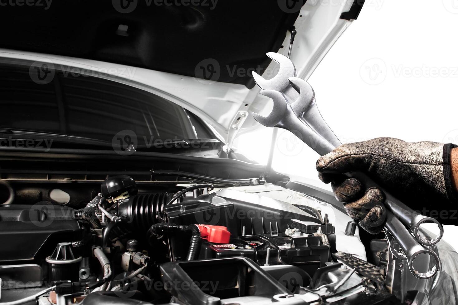 Car Engine Repair, A gloved hand holds wrenches over an open car engine. Auto mechanic, Vehicle maintenance service. photo
