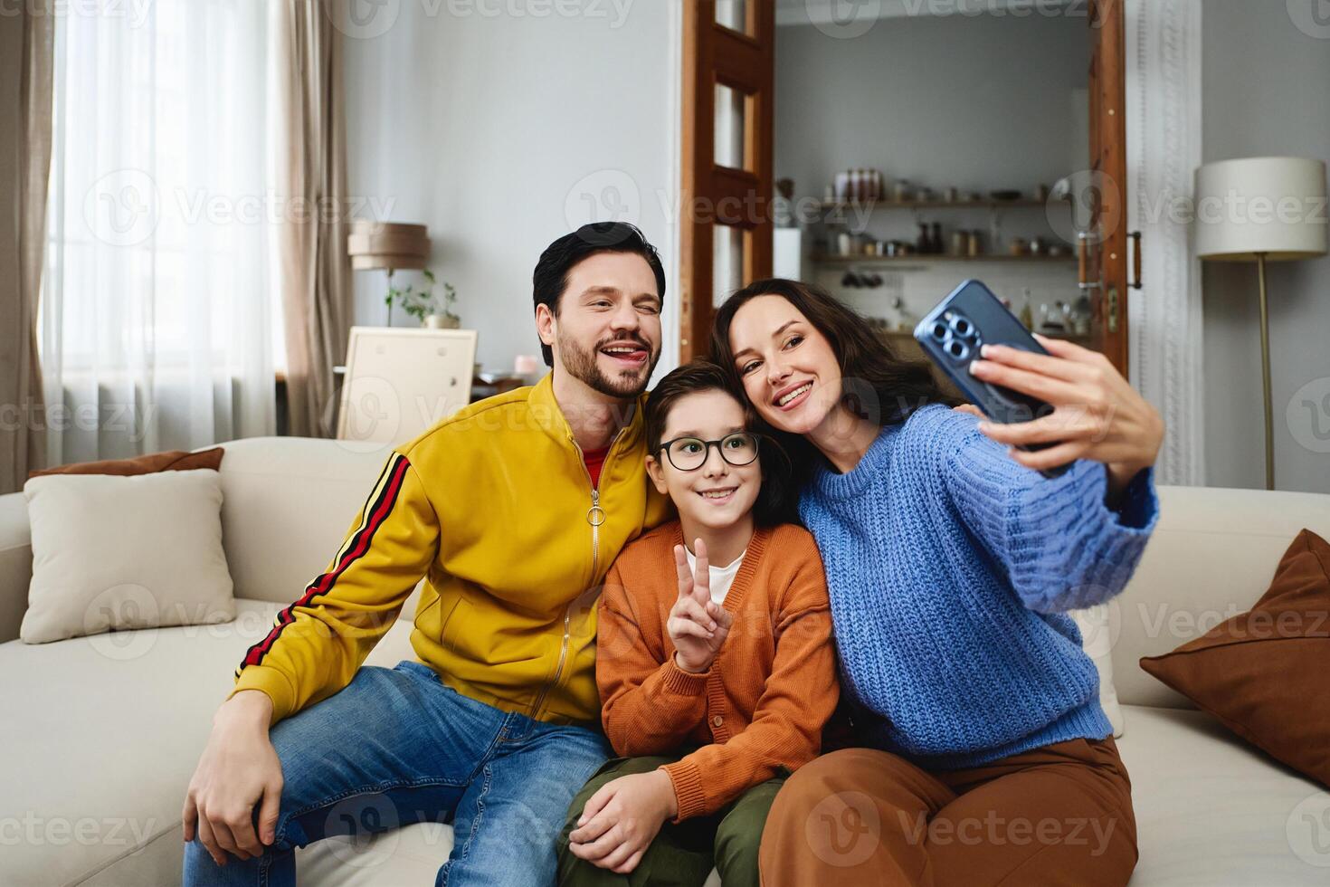 Family enjoying a cozy afternoon together while taking a selfie at home photo