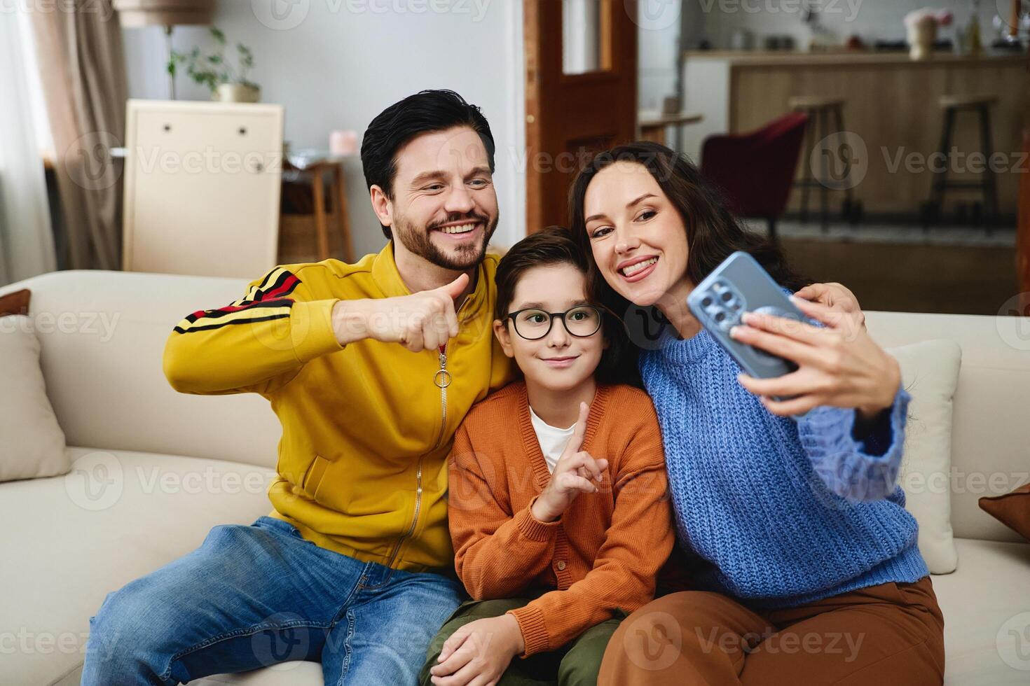 Family enjoys quality time while taking a selfie in their cozy living room photo