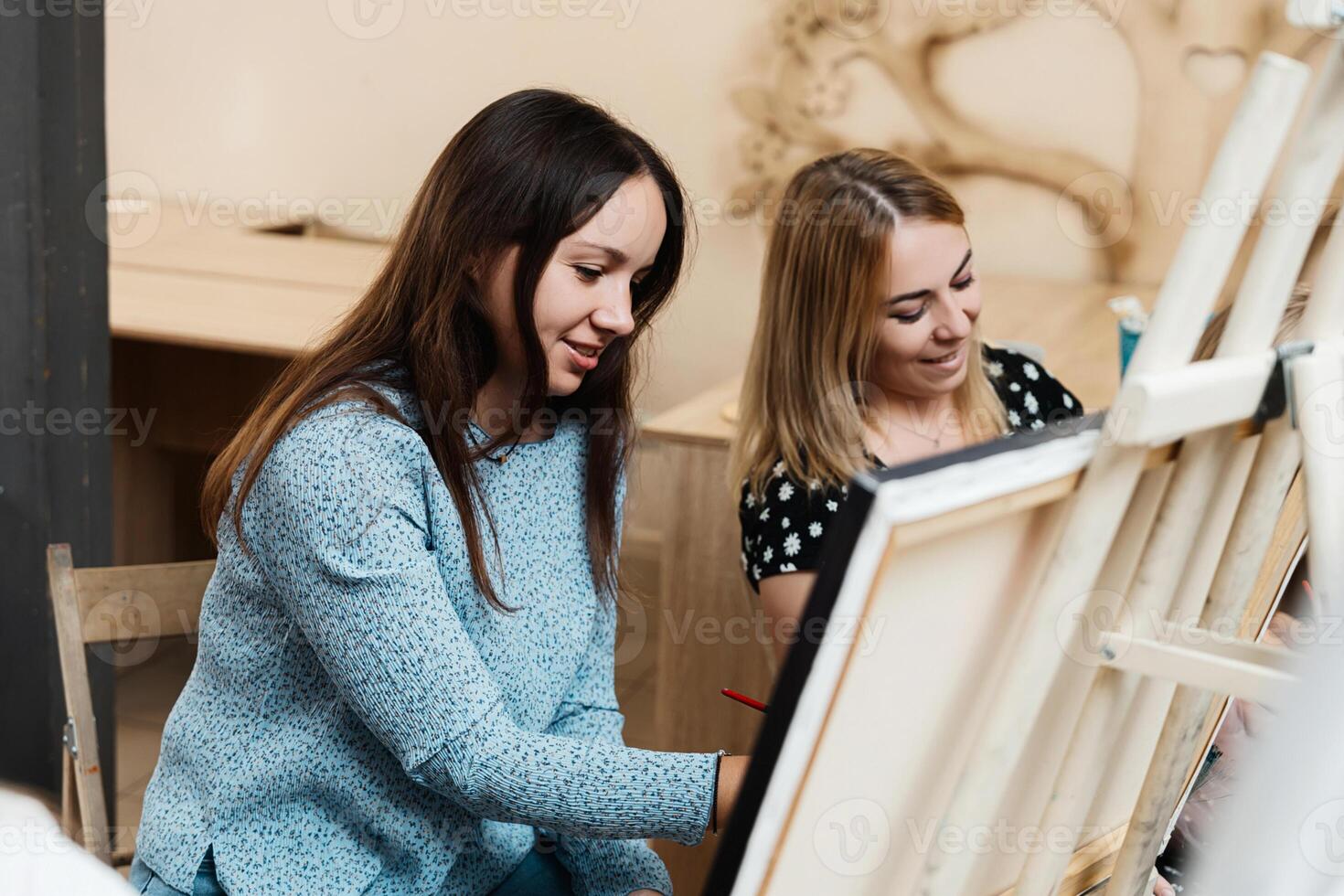 Two women enjoy a painting session in an art studio during daytime photo