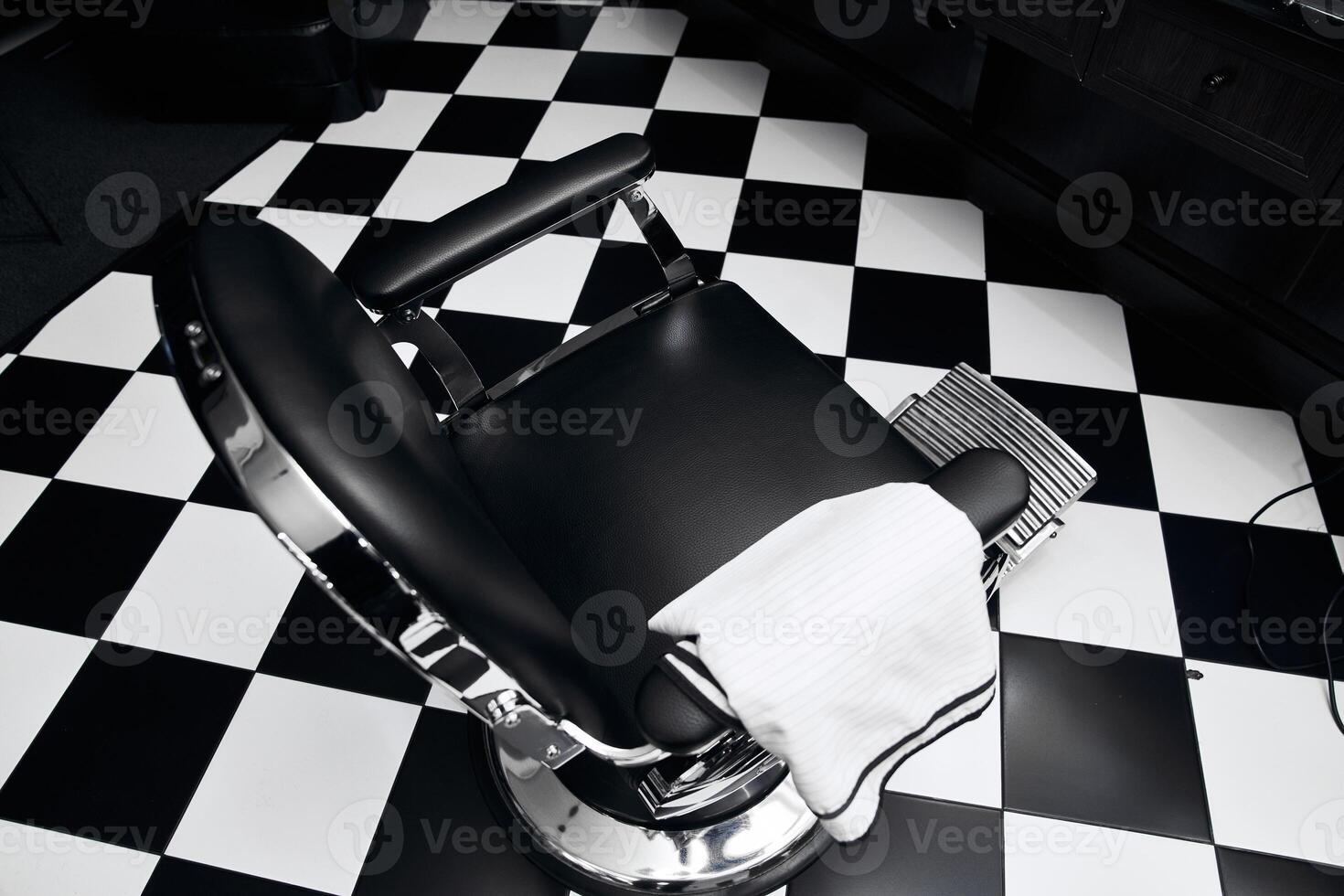 Barber chair in a stylish salon with black and white flooring design photo