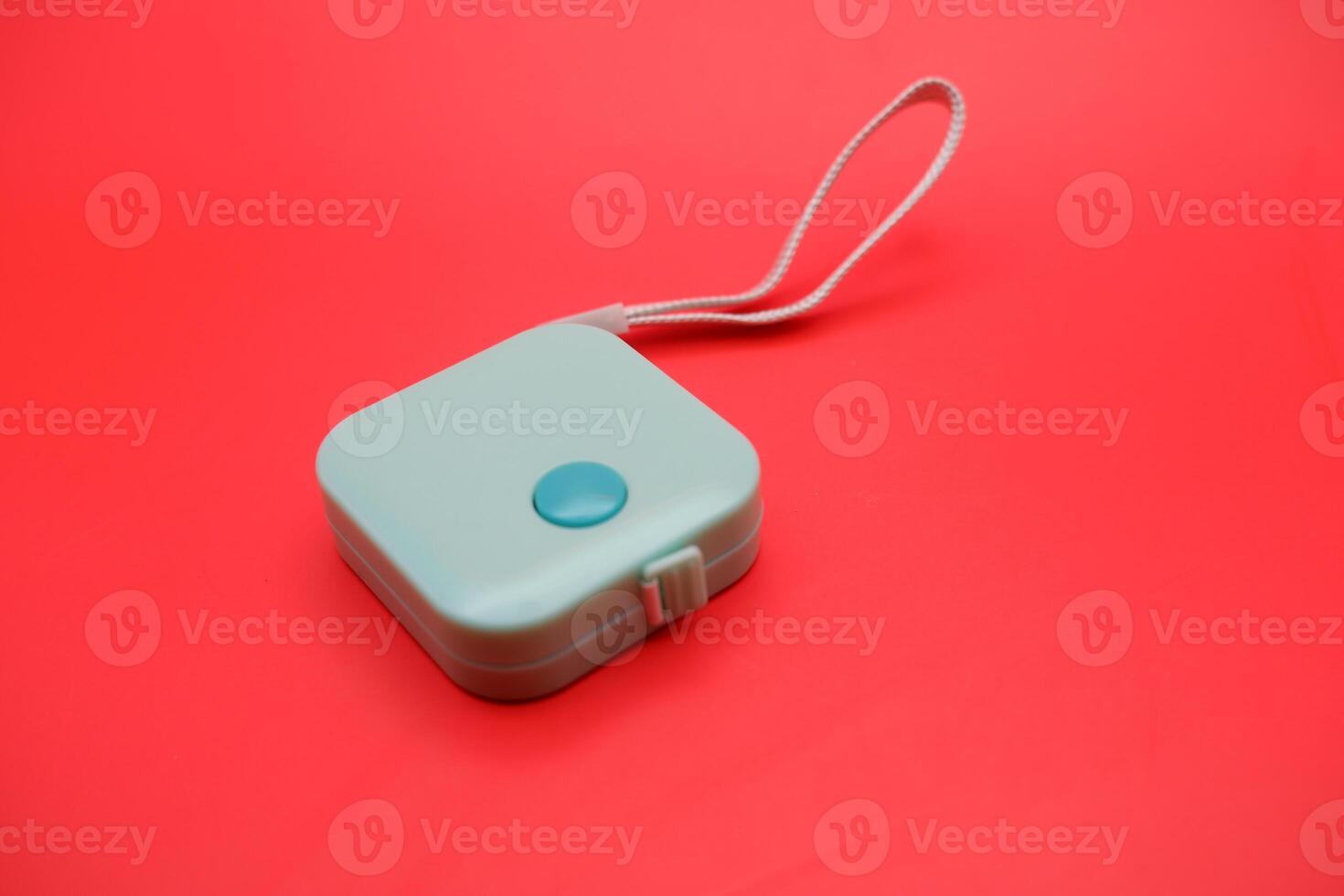 Tailor's green measuring tape on bright red surface, symbolizing measurement, accuracy, and fashion in a modern layout. photo