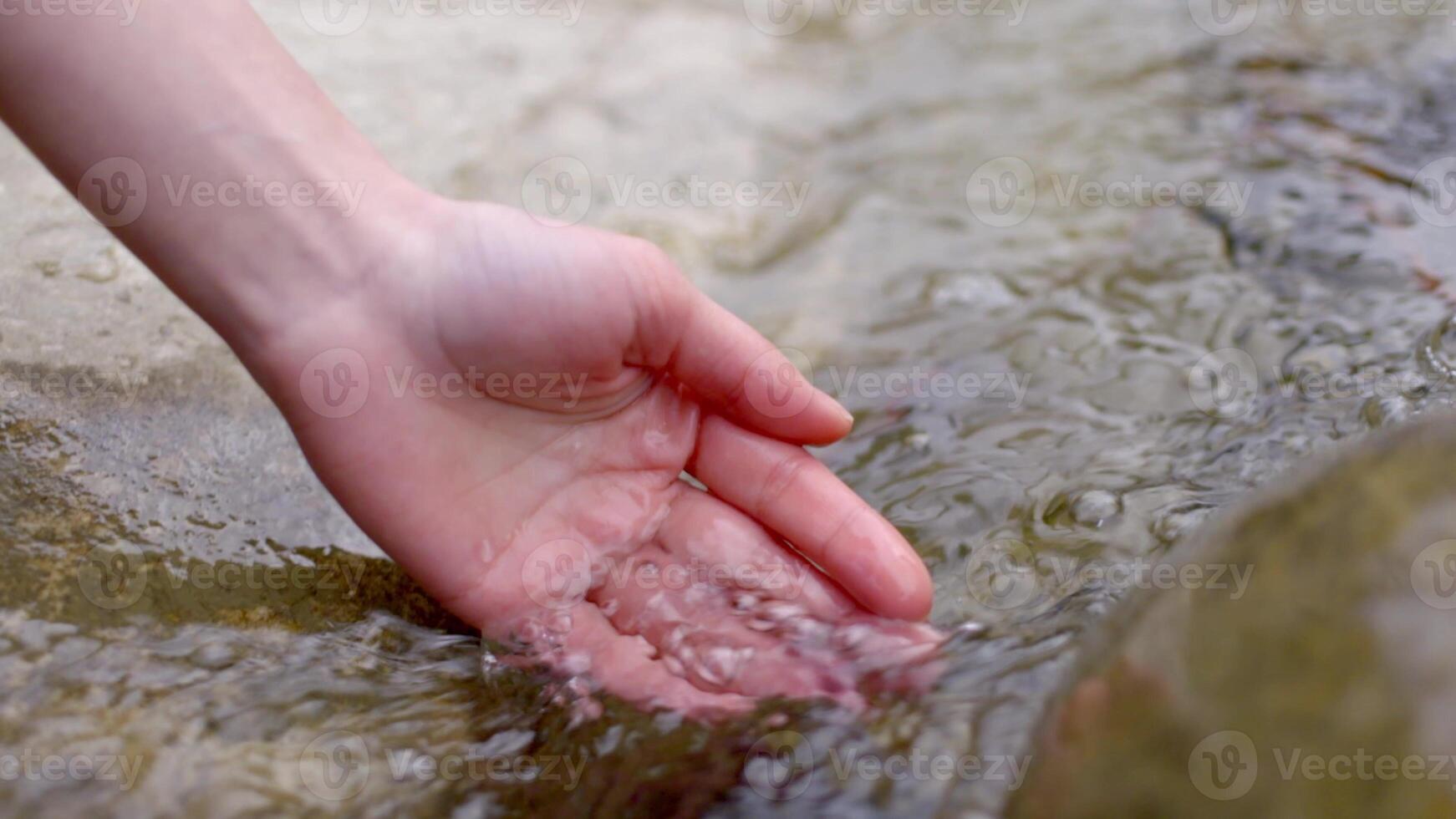 Collecting water from river into hand palm photo