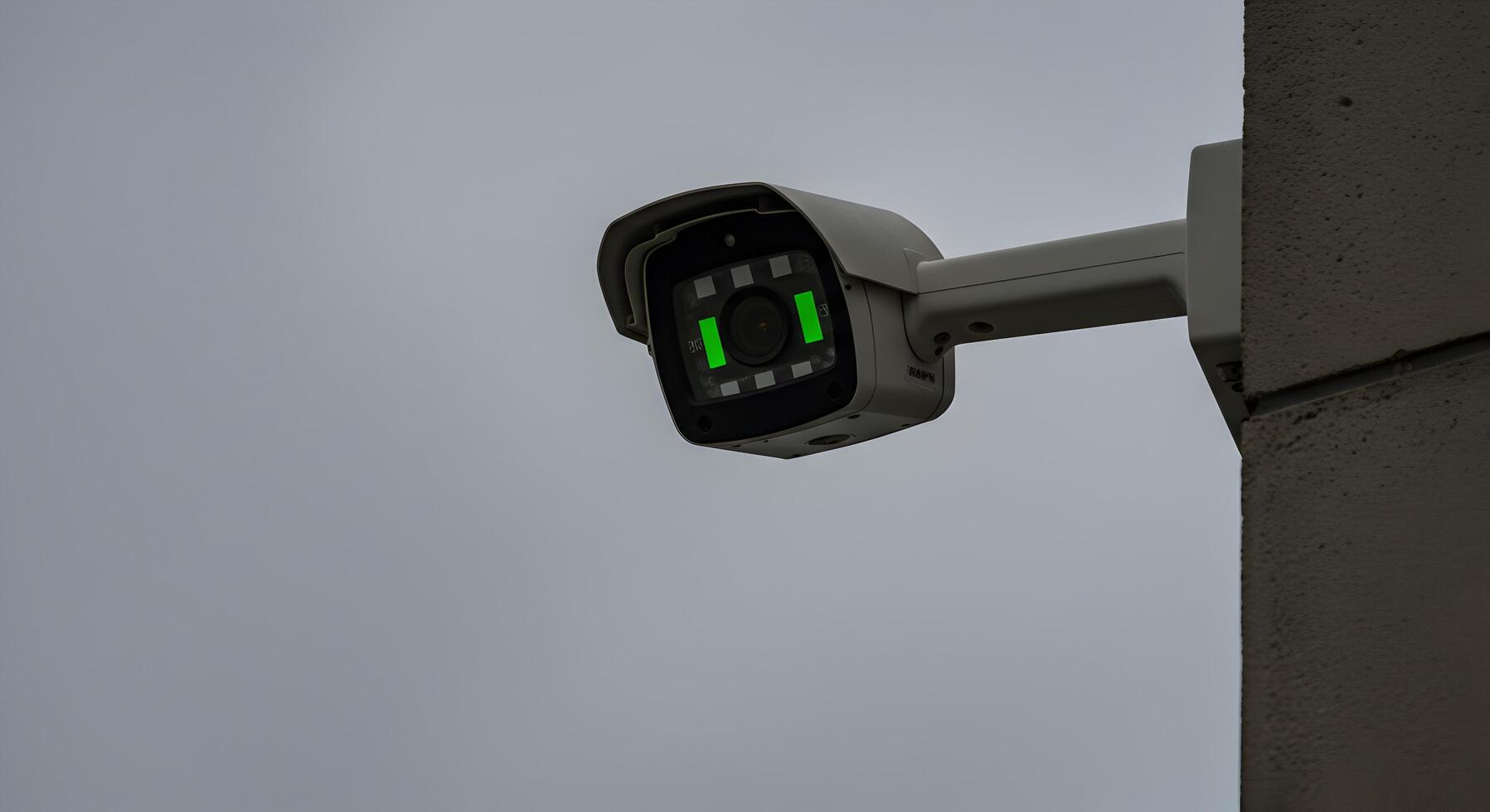 Surveillance camera mounted on building corner, offering enhanced security photo