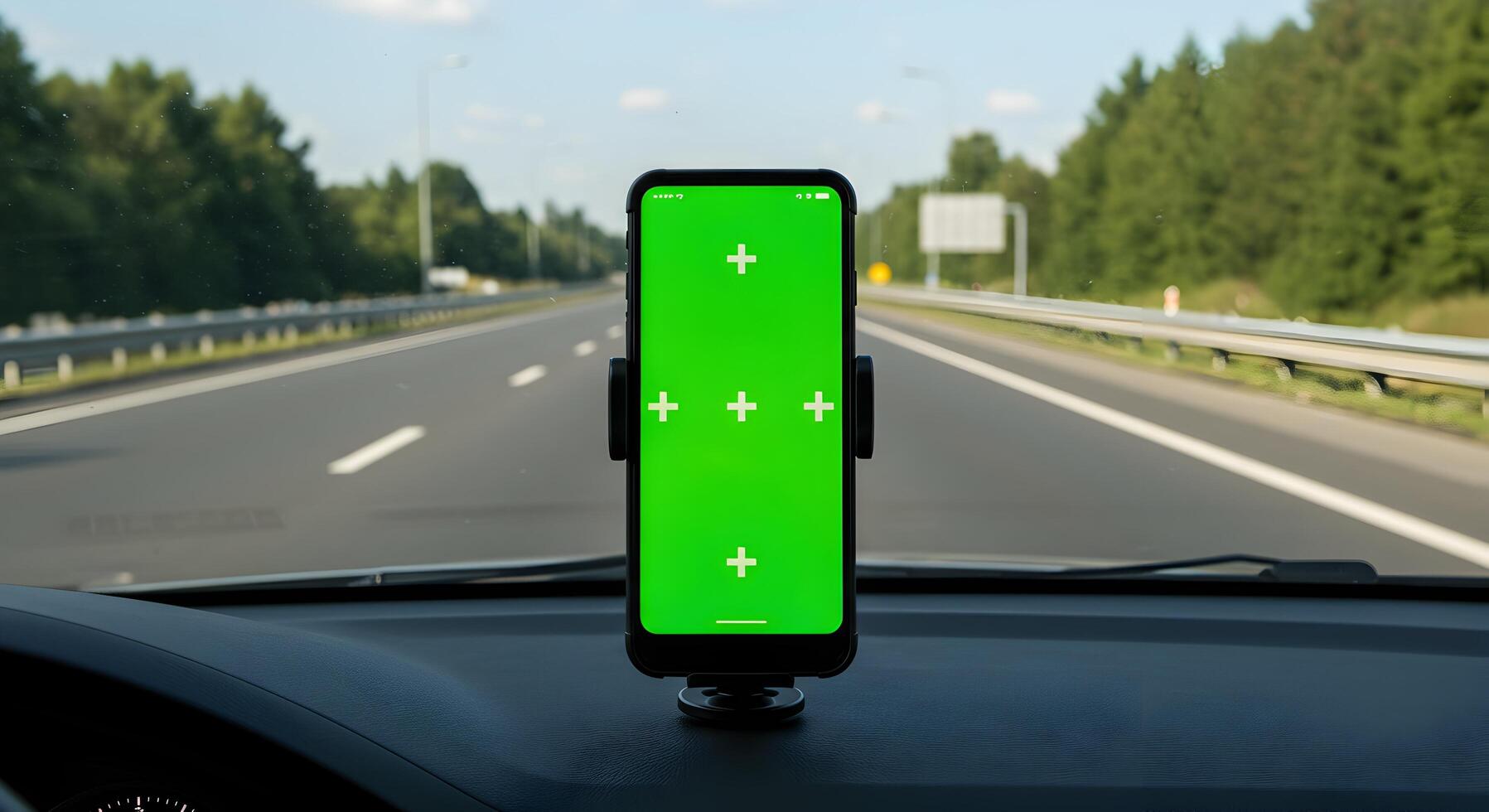Smartphone displaying chroma key screen mounted on a vehicle dashboard offering a view photo