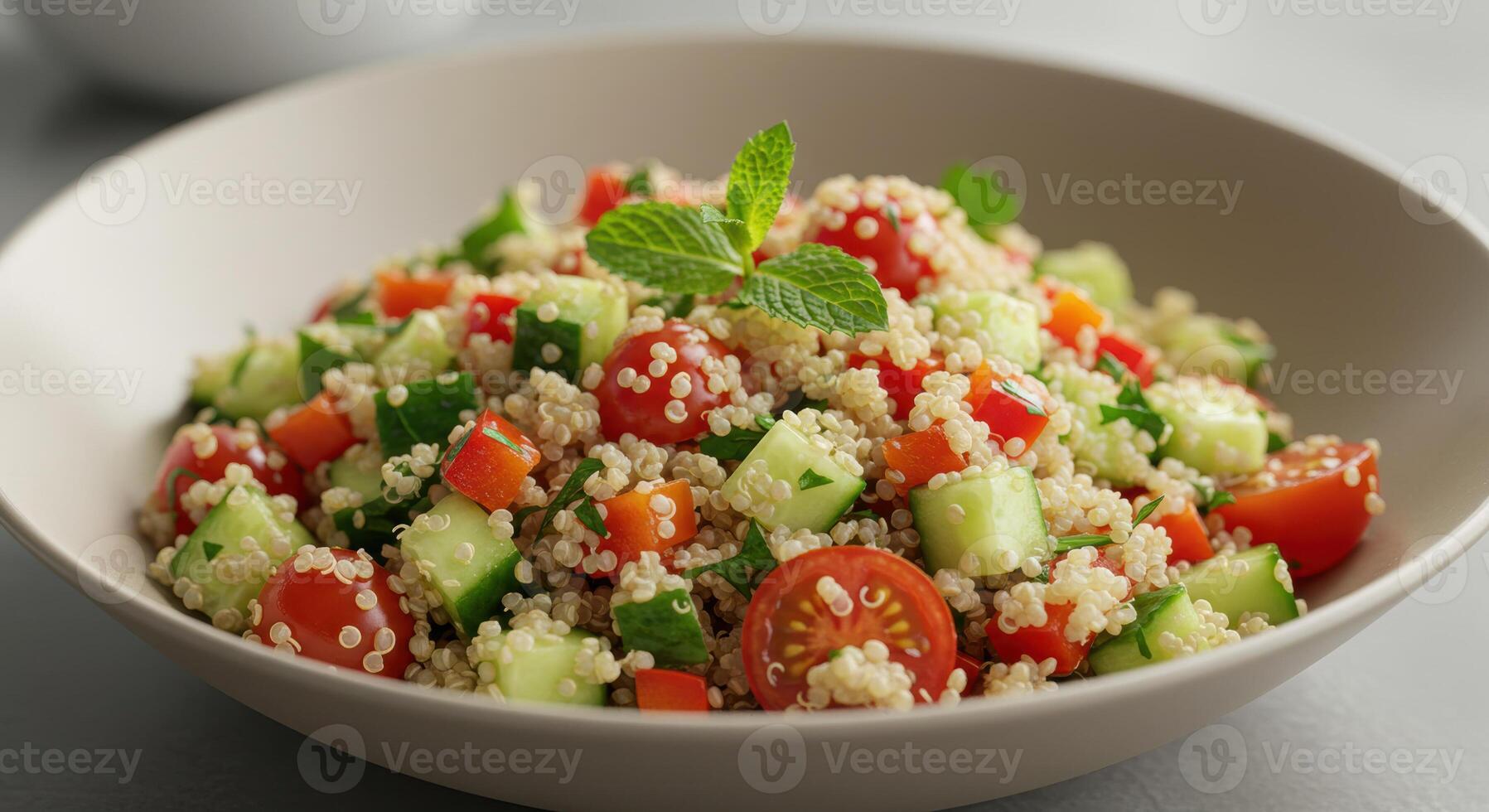 A delicious and healthy quinoa salad served in a white bowl with colorful fresh vegetables. photo