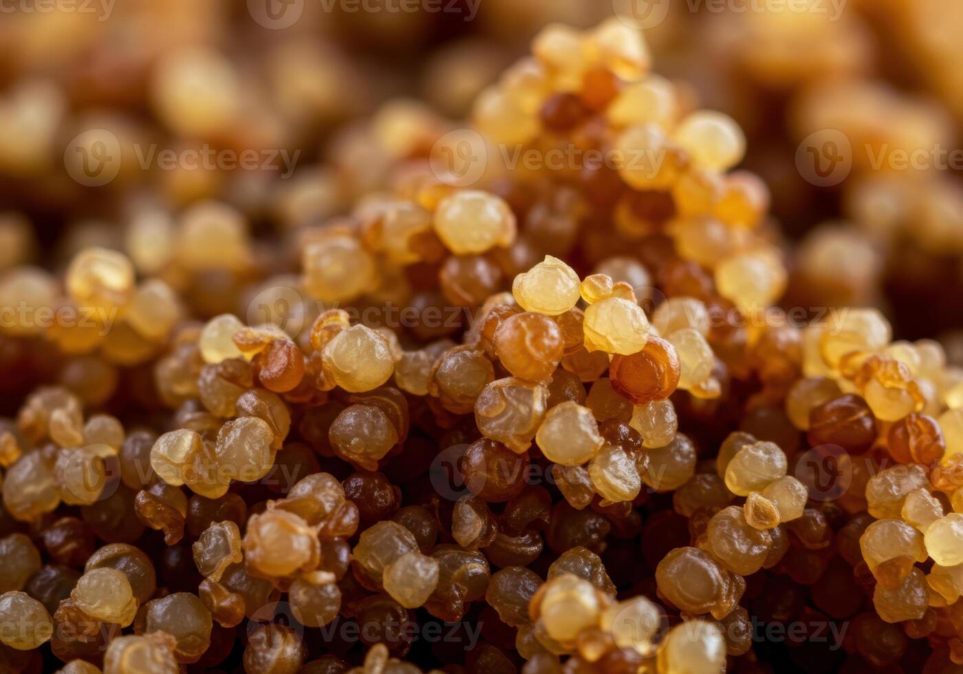 A detailed capture of small, amber-toned resin droplets, clustered together, filling the frame. photo