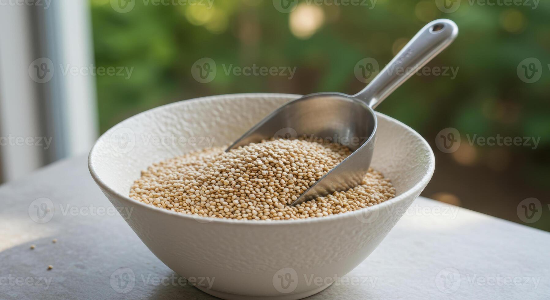 Close up of a bowl filled with quinoa and a metal scoop, ready to prepare a meal. photo