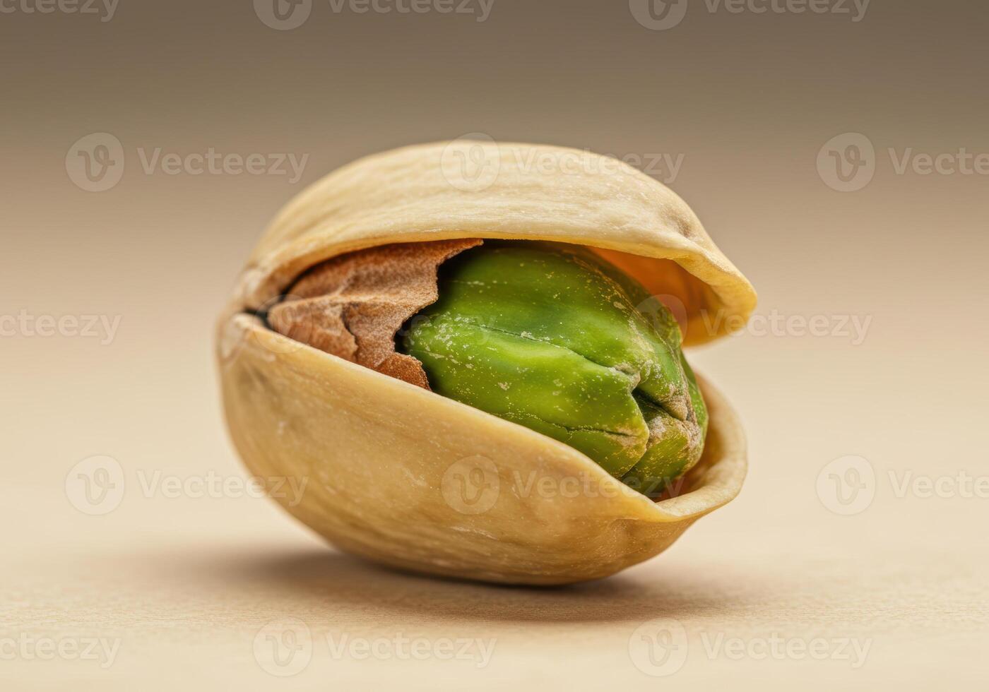 A close up of a cracked pistachio, revealing the vibrant green nut inside the shell. photo