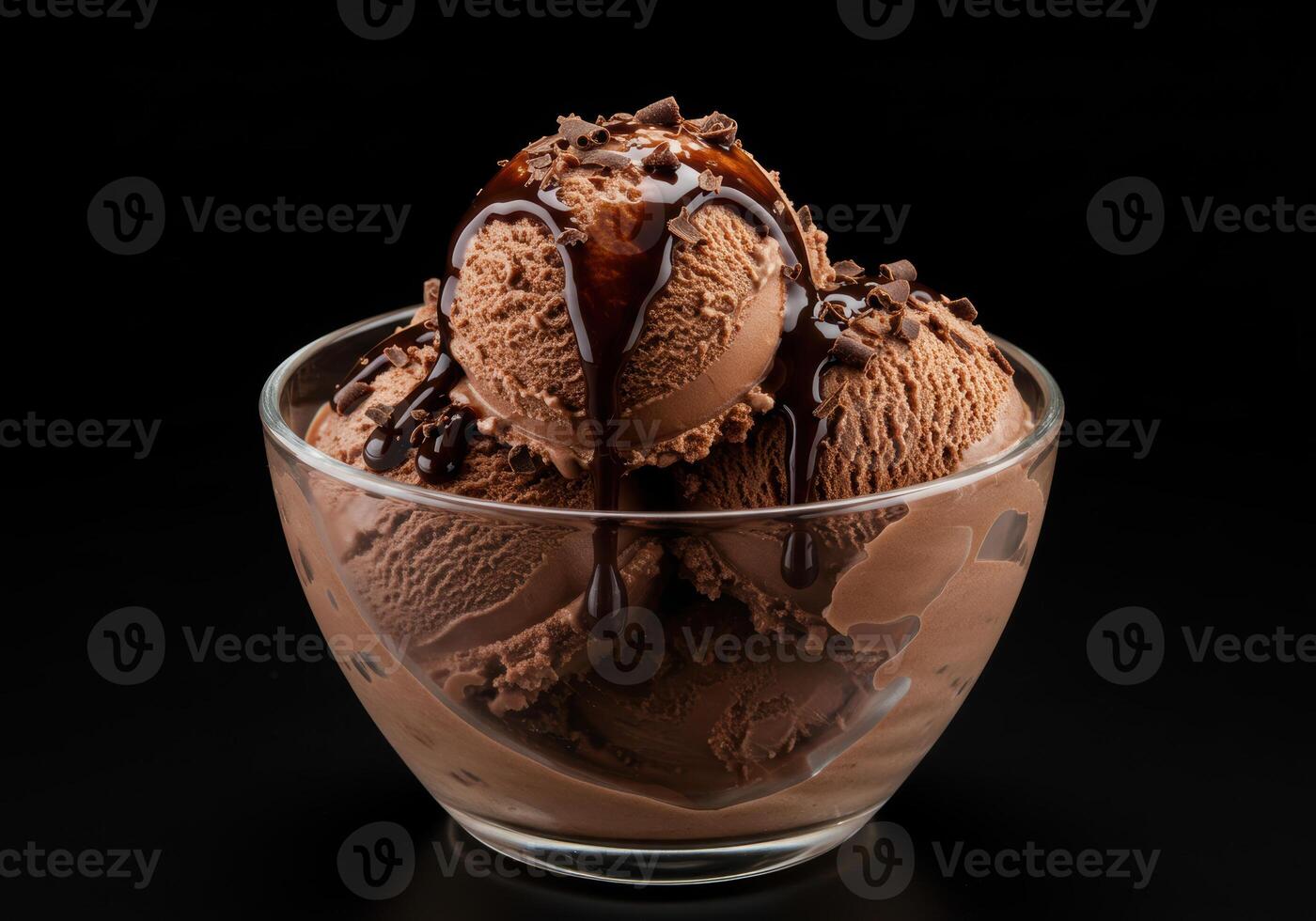Delectable chocolate ice cream scoops in a clear glass bowl with rich chocolate drizzle. photo