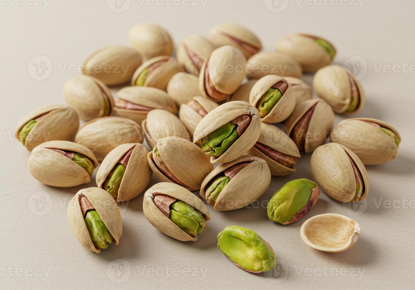 A group of fresh pistachios, some shelled, sit together on a light surface. photo