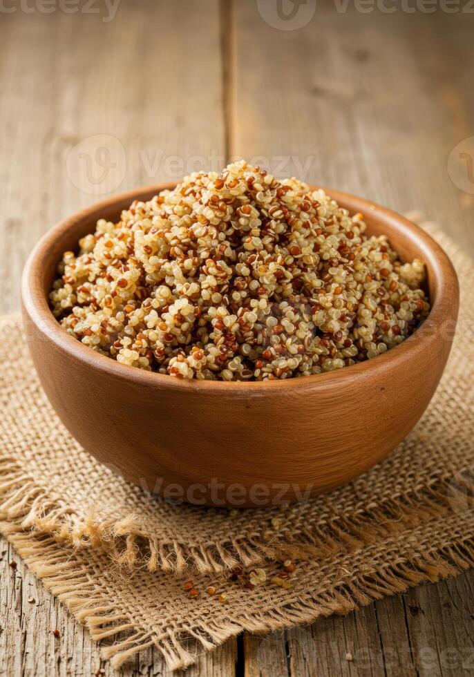 A close up shot showcases a wooden bowl filled with fluffy, cooked quinoa. photo