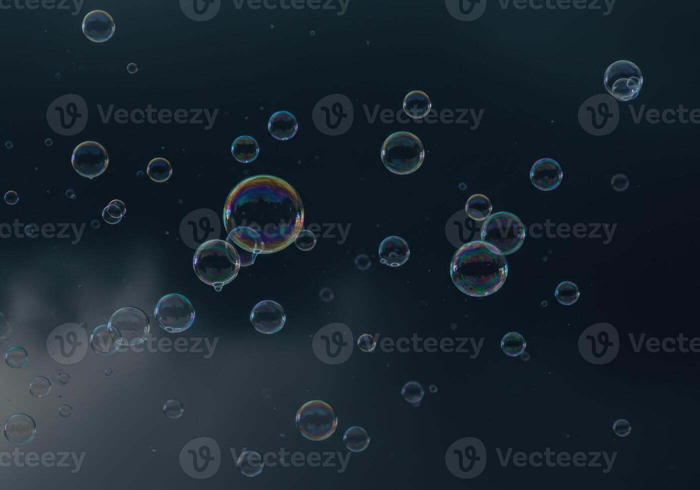 Numerous translucent bubbles float in the air with reflections of light and color. photo