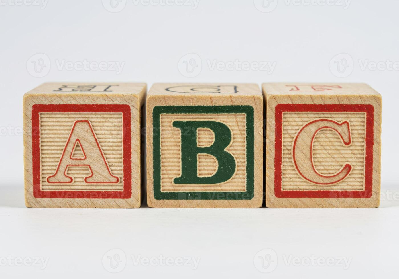Three wooden blocks spelling the alphabet letters A, B, and C in a row. photo