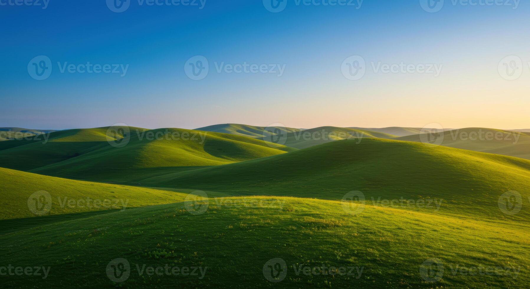 Gentle hills of vibrant green carpet a vast landscape under a clear, bright blue sky. photo
