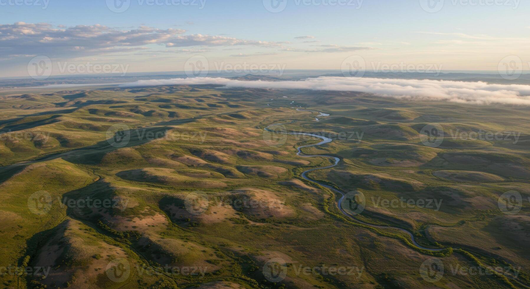 A beautiful aerial view of a lush green landscape with a winding river under a clear sky. photo