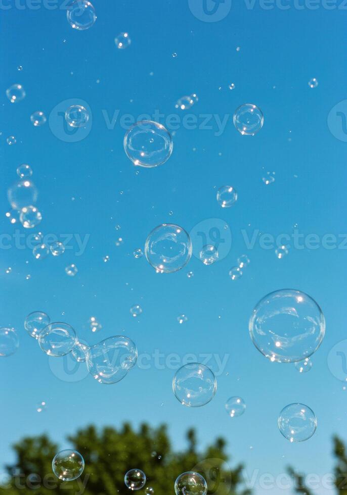 A playful scene filled with floating bubbles against a clear, vibrant blue sky. photo