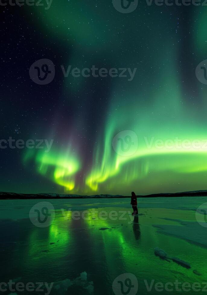 A solitary individual marvels at the breathtaking aurora borealis display across the night. photo