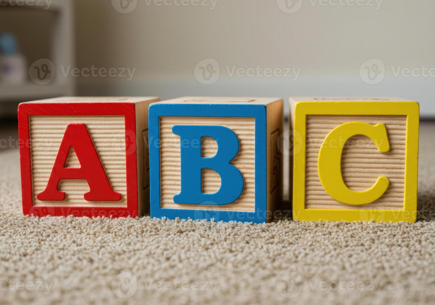 Three colorful blocks with the letters A, B, and C sit together on a soft carpet. photo