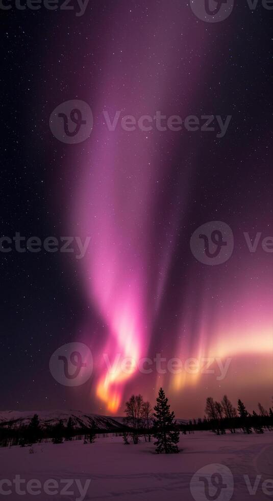 Captivating display of aurora borealis dancing in the night sky above a snowy terrain. photo