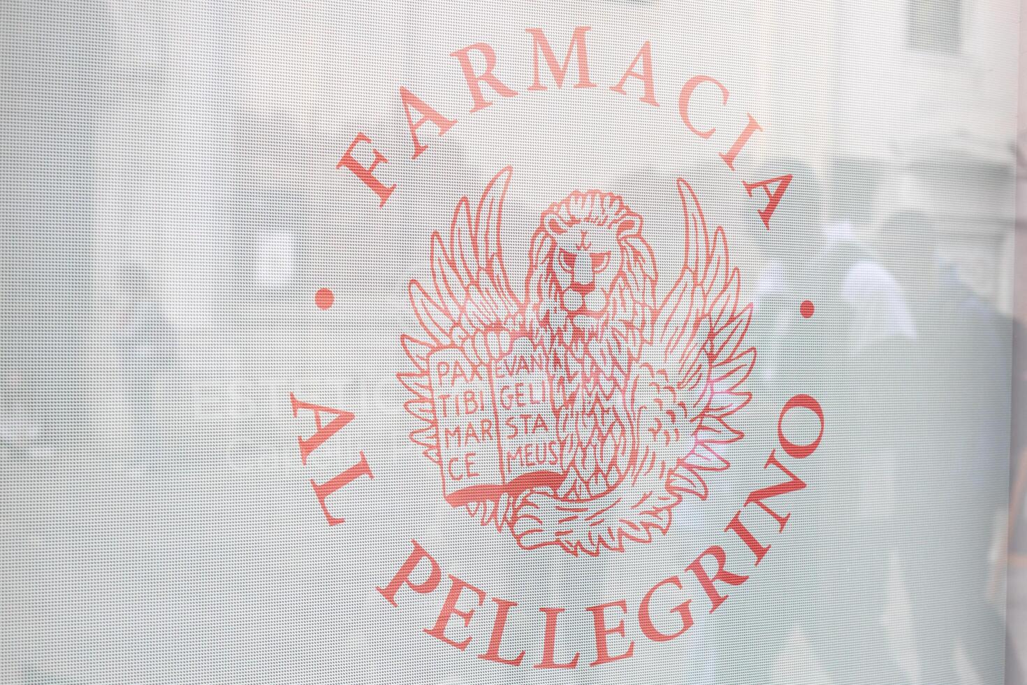 Venice, Italy - April 20 2025 Logo of Farmacia al Pellegrino with Venetian lion on pharmacy window photo