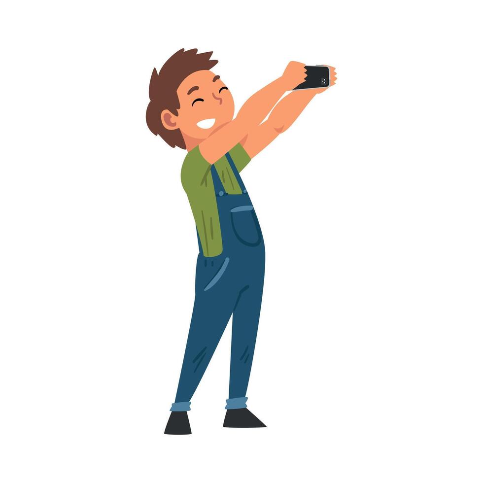 Smiling Boy in Overalls Taking Selfie Photo, Cute Child Character Photographing Himself with Smartphone Cartoon Illustration vector