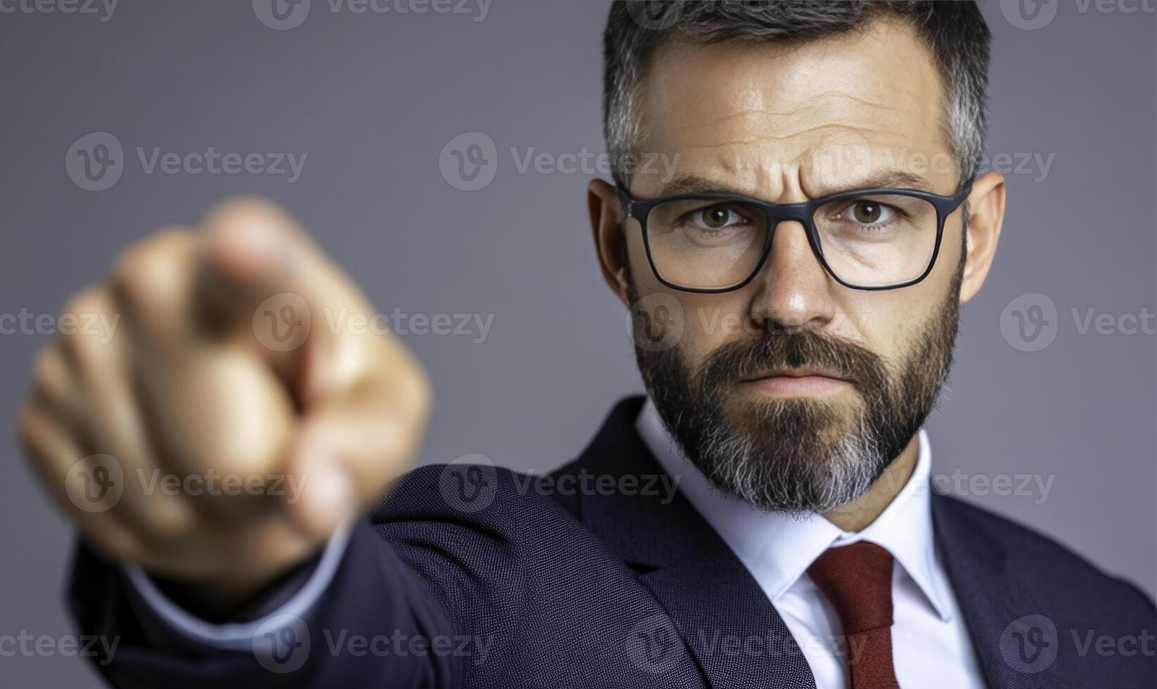 Confident Businessman in Suit Pointing at Camera with Intense Expression, Demonstrating Authority and Leadership in Professional Environment photo
