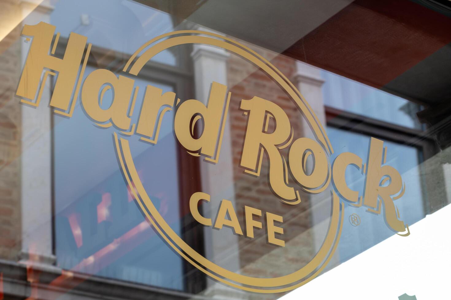 Venice, Italy - April 17 2025 Hard Rock Cafe logo with Venetian architecture reflection in glass photo