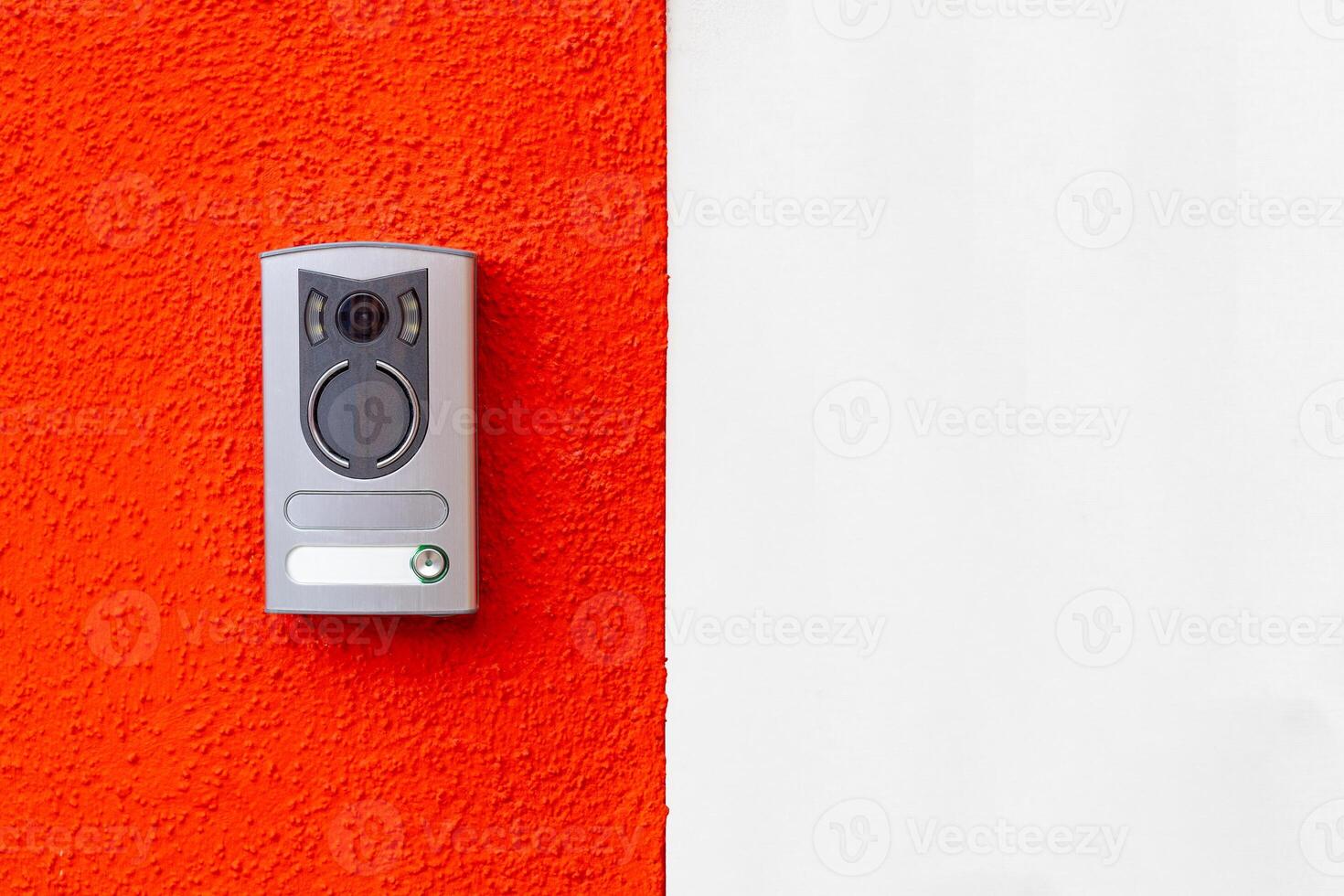 Modern door intercom on red and white wall photo