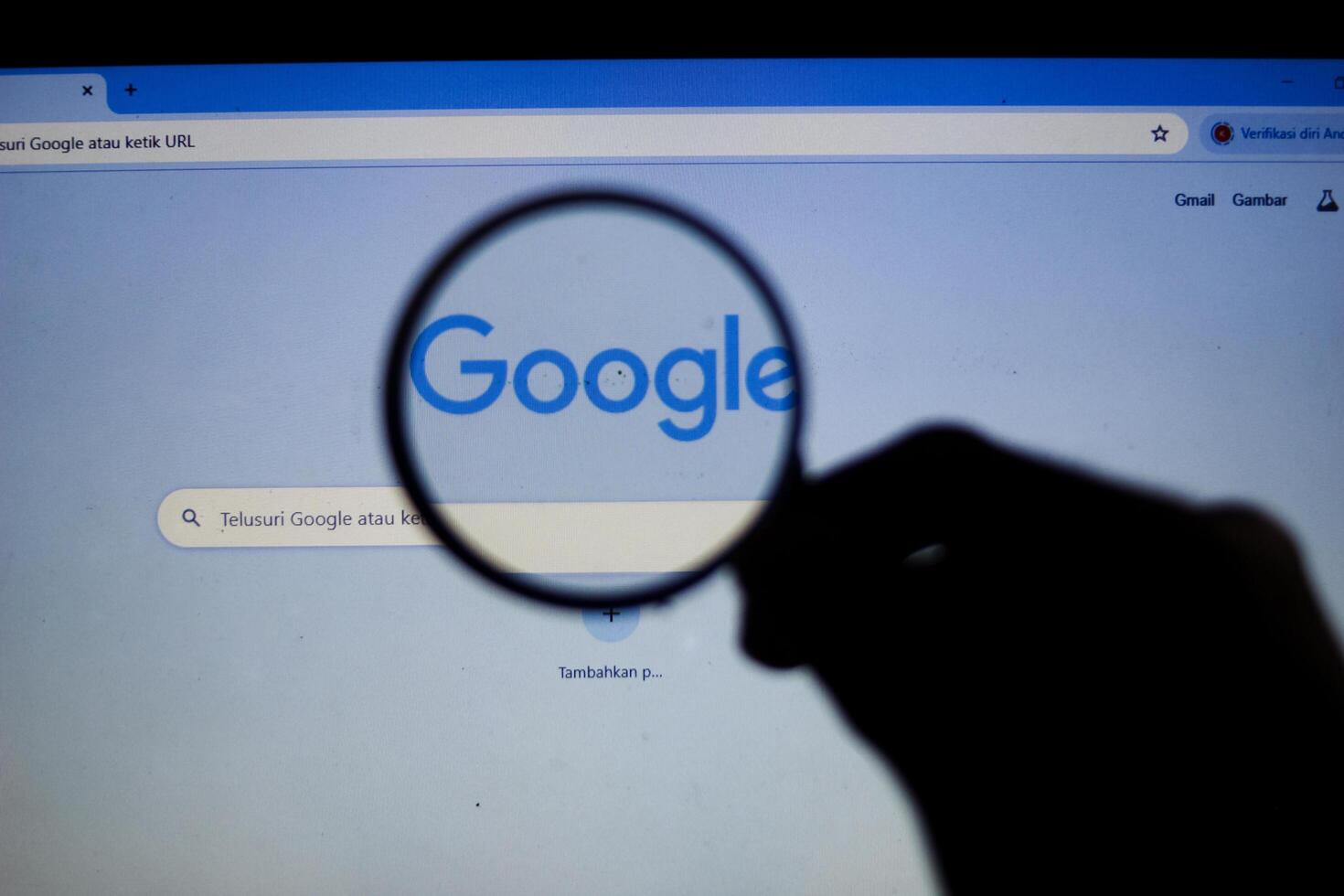 Medan Indonesia, April 09, 2024 - google search magnified. close up of the google search page viewed through a magnifying glass photo