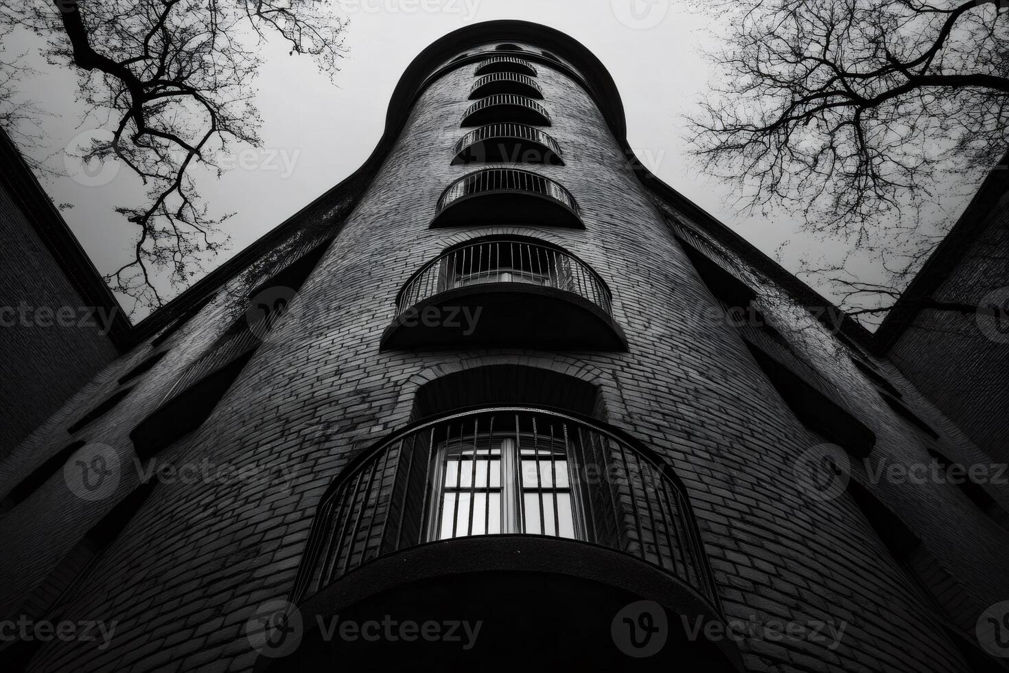 Low angle view of brick building with balconies reaching for cloudy sky photo