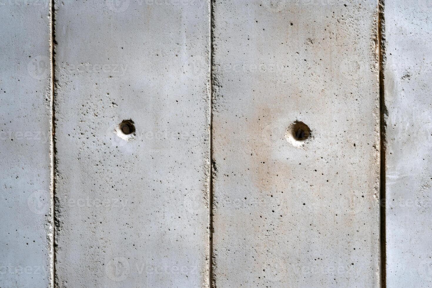 Two bullet holes piercing a concrete wall, a symbol of violence photo