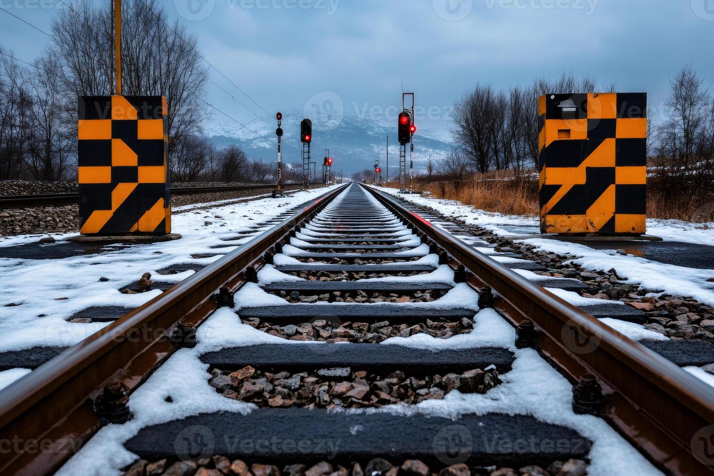 Railway tracks covered with snow leading to red signal lights in winter photo