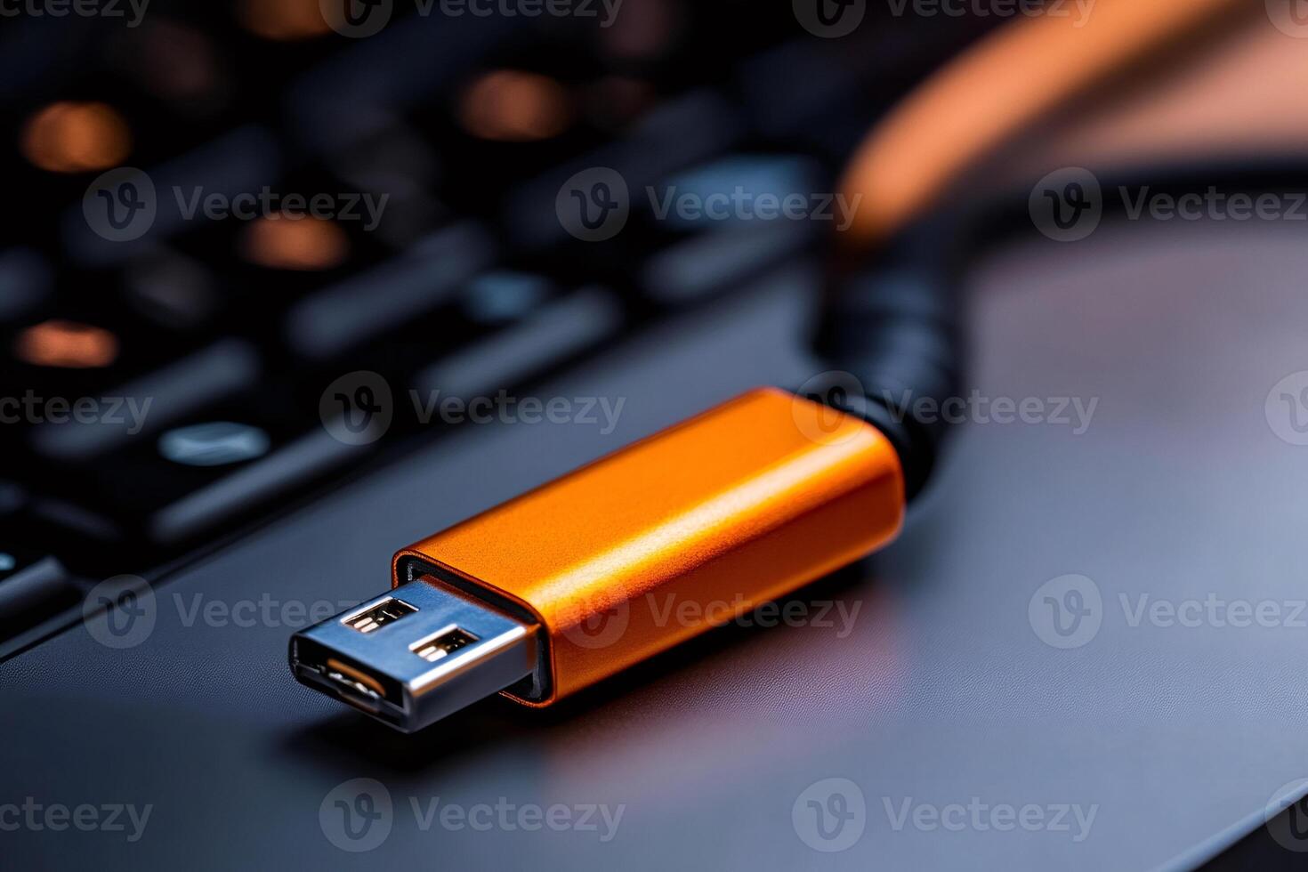 Orange usb flash drive lying on laptop keyboard, connecting to technology photo