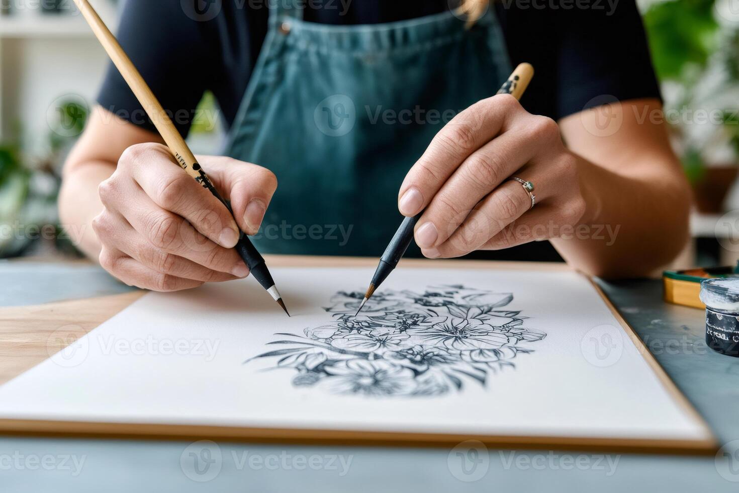 Artist drawing flowers with ink brushes in art studio photo