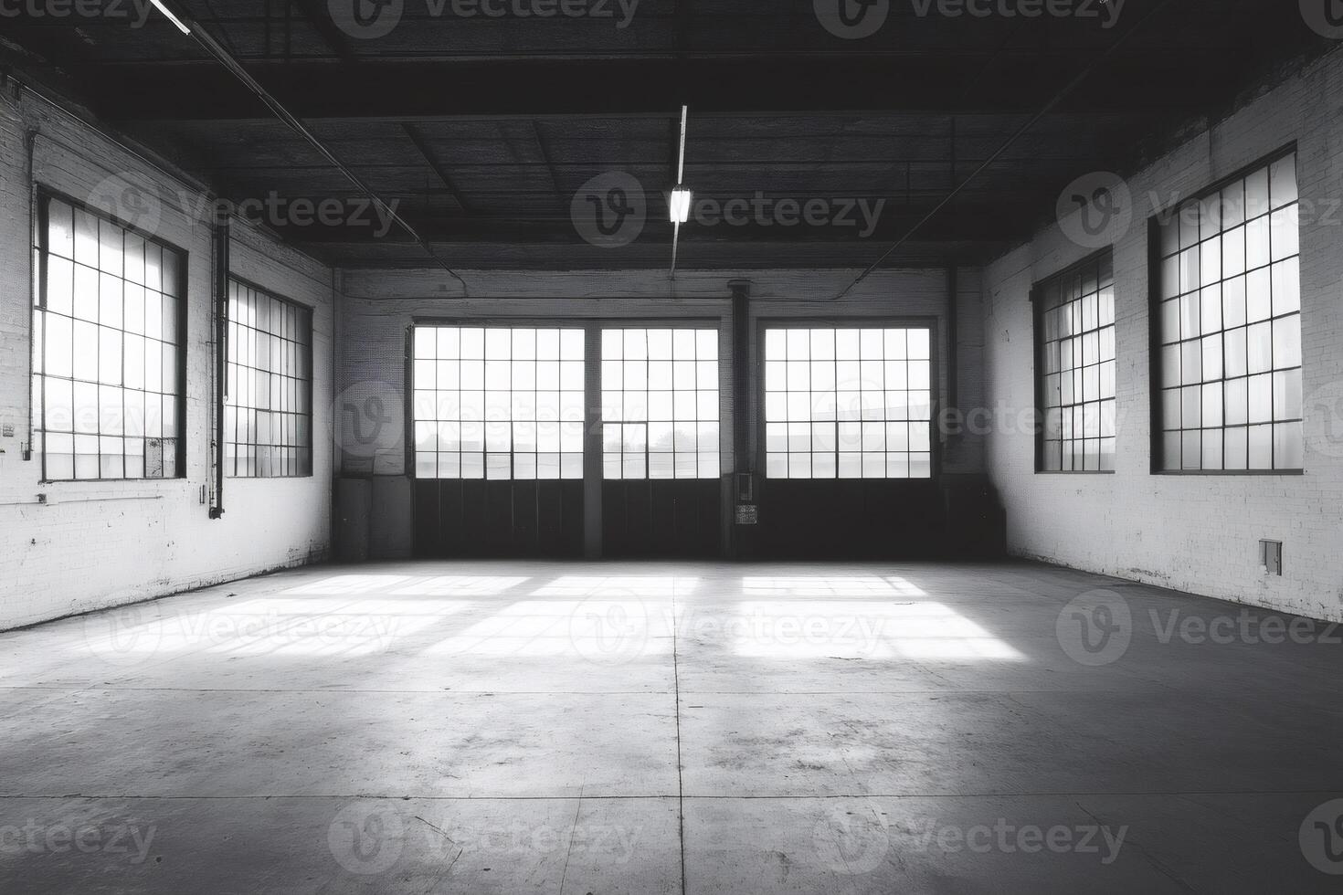 Sunlight illuminating empty industrial warehouse through large windows photo