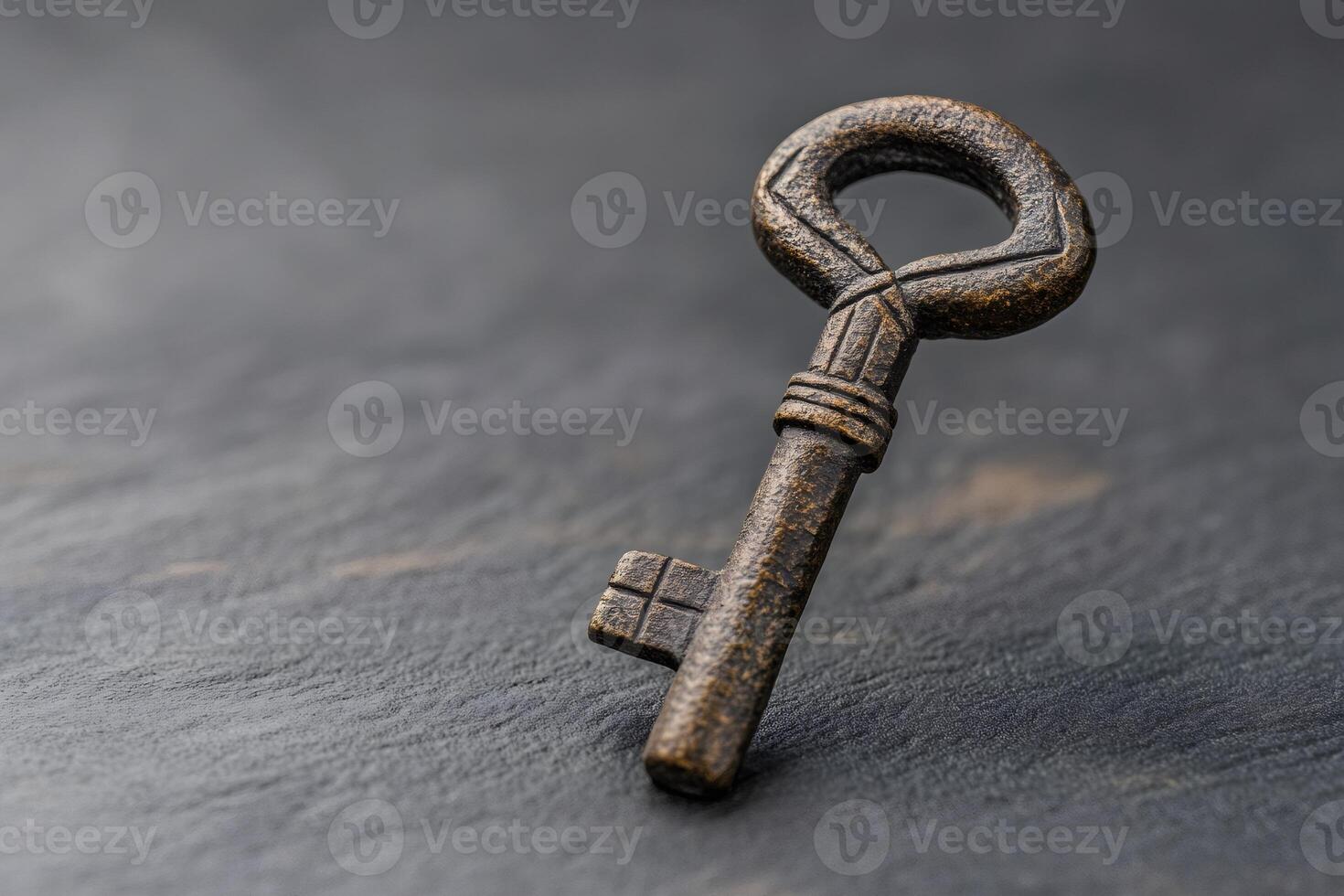 Old key resting on dark stone surface symbolizing history and mystery photo
