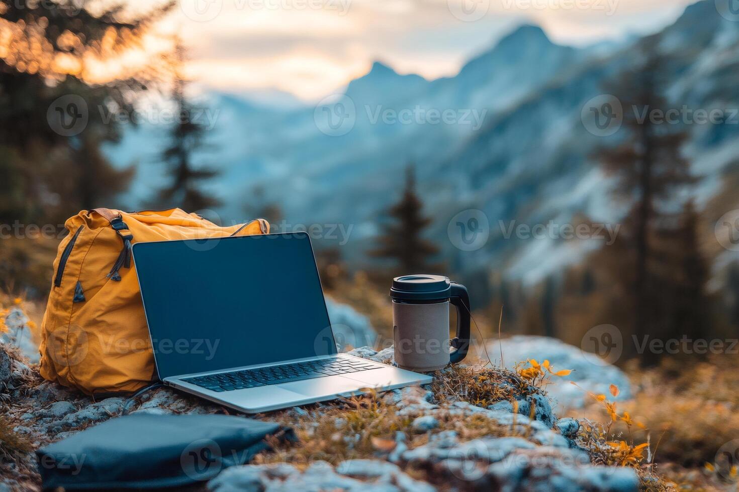 Laptop and backpack enabling remote work in mountain scenery at sunset photo
