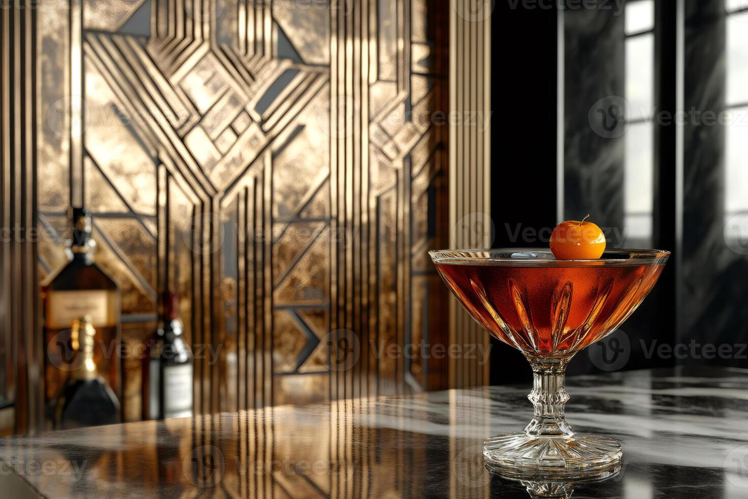 Elegant crystal glass with a cocktail and cherry, resting on a marble bar countertop in front of a gold art deco backdrop photo