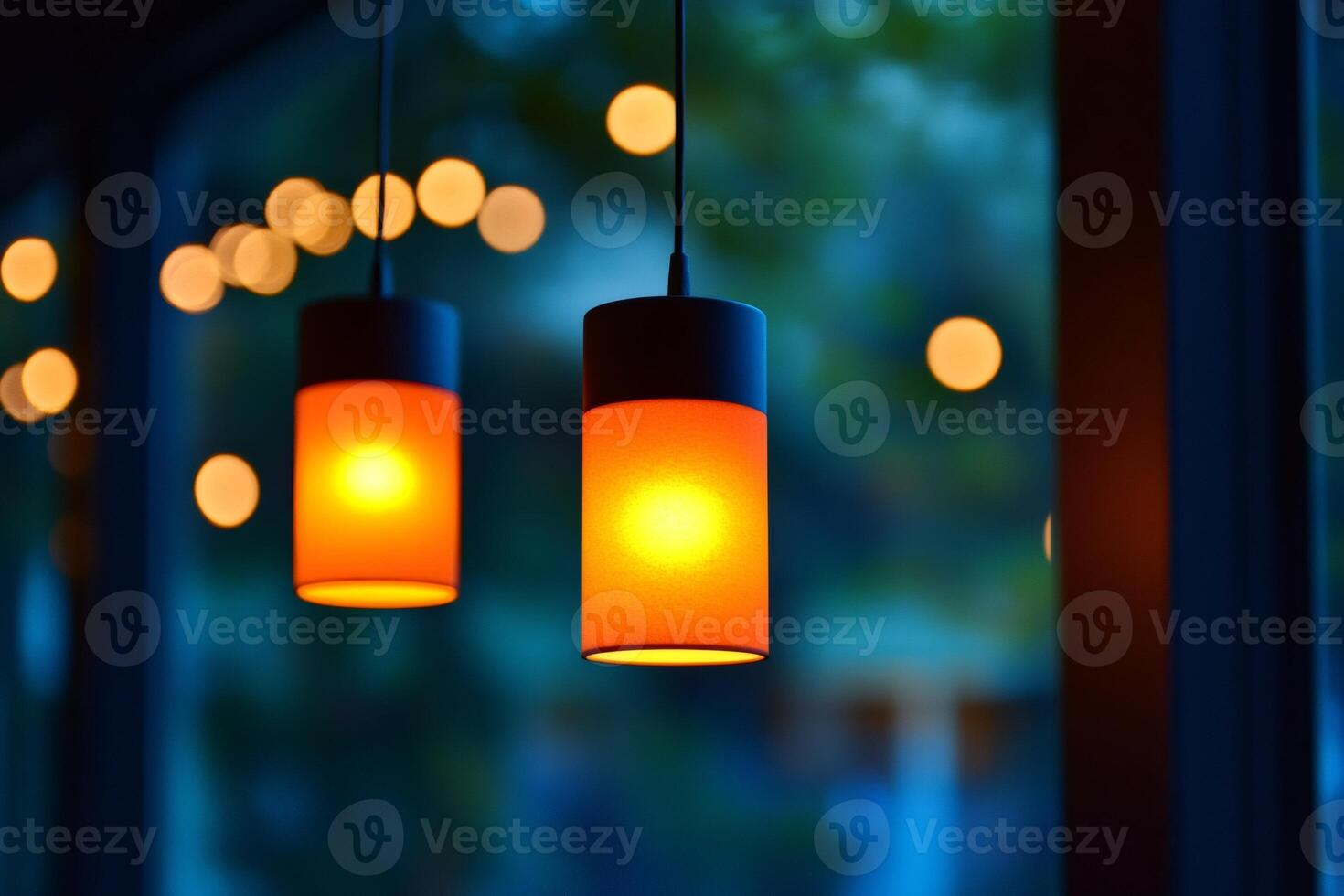 Two orange hanging lamps illuminating a blurred background photo