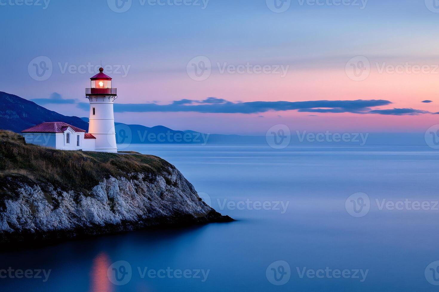 Lighthouse guiding ships at dusk on a tranquil coastline photo